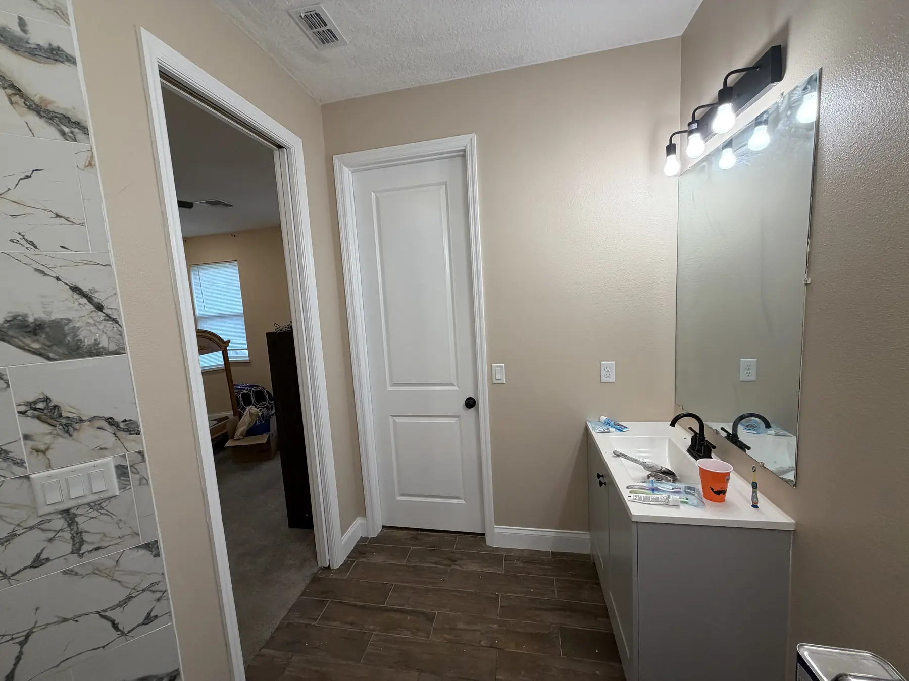 Bathroom with repainted taupe walls, a white ceiling, and a freshly painted white door