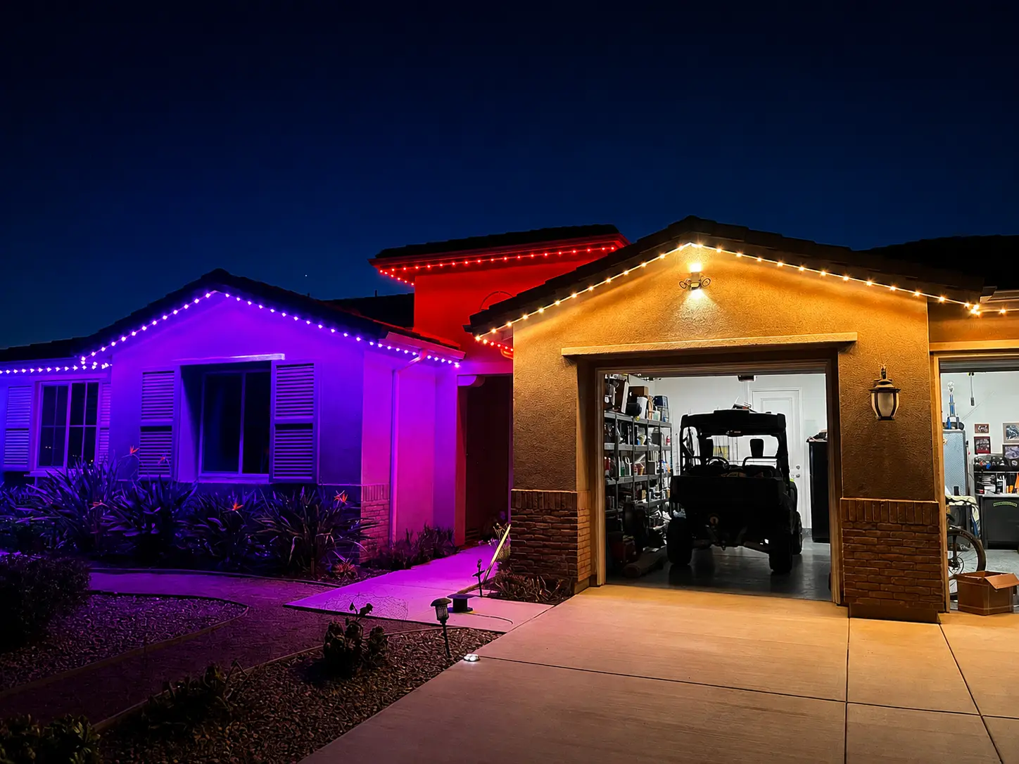 Home exterior illuminated with purple, red, orange, and white permanent lights