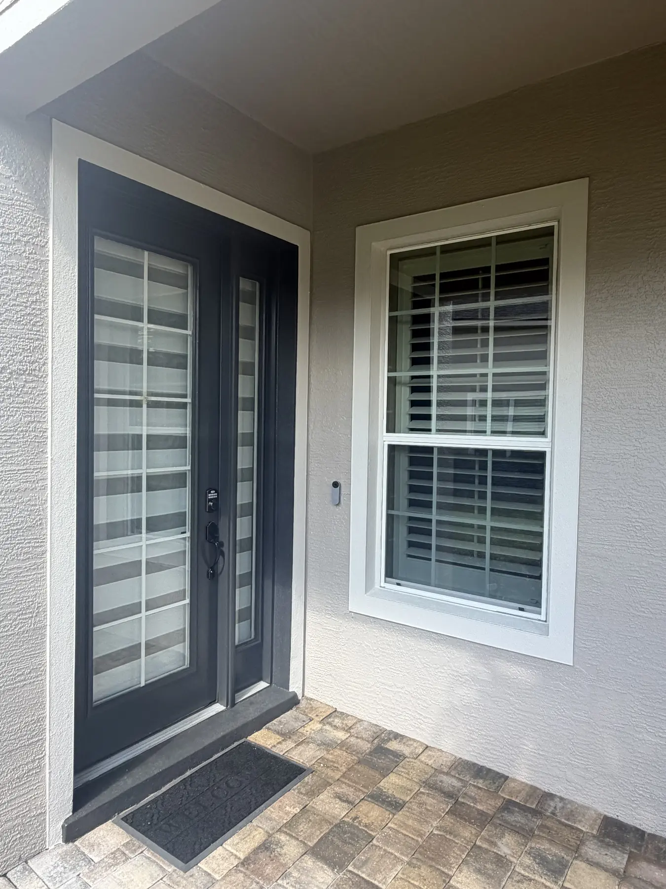 Compact security light installed between a front door and window