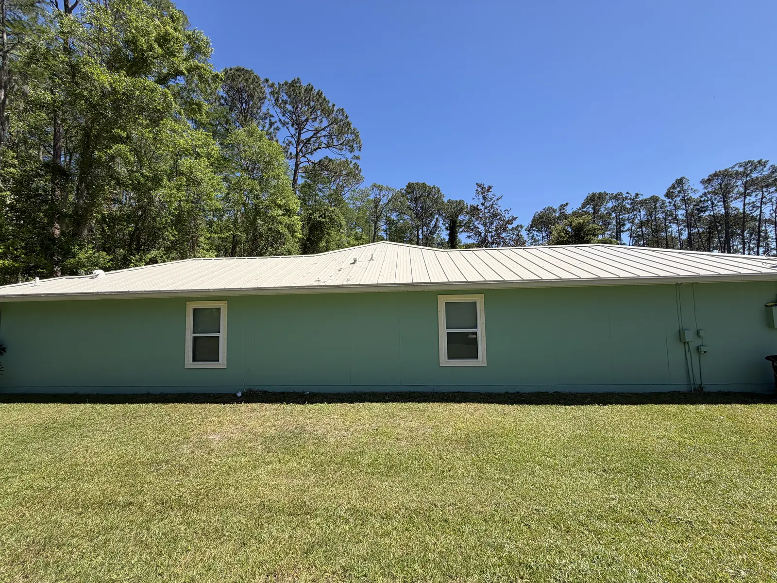Clean pale green home exterior after a whole-home soft wash