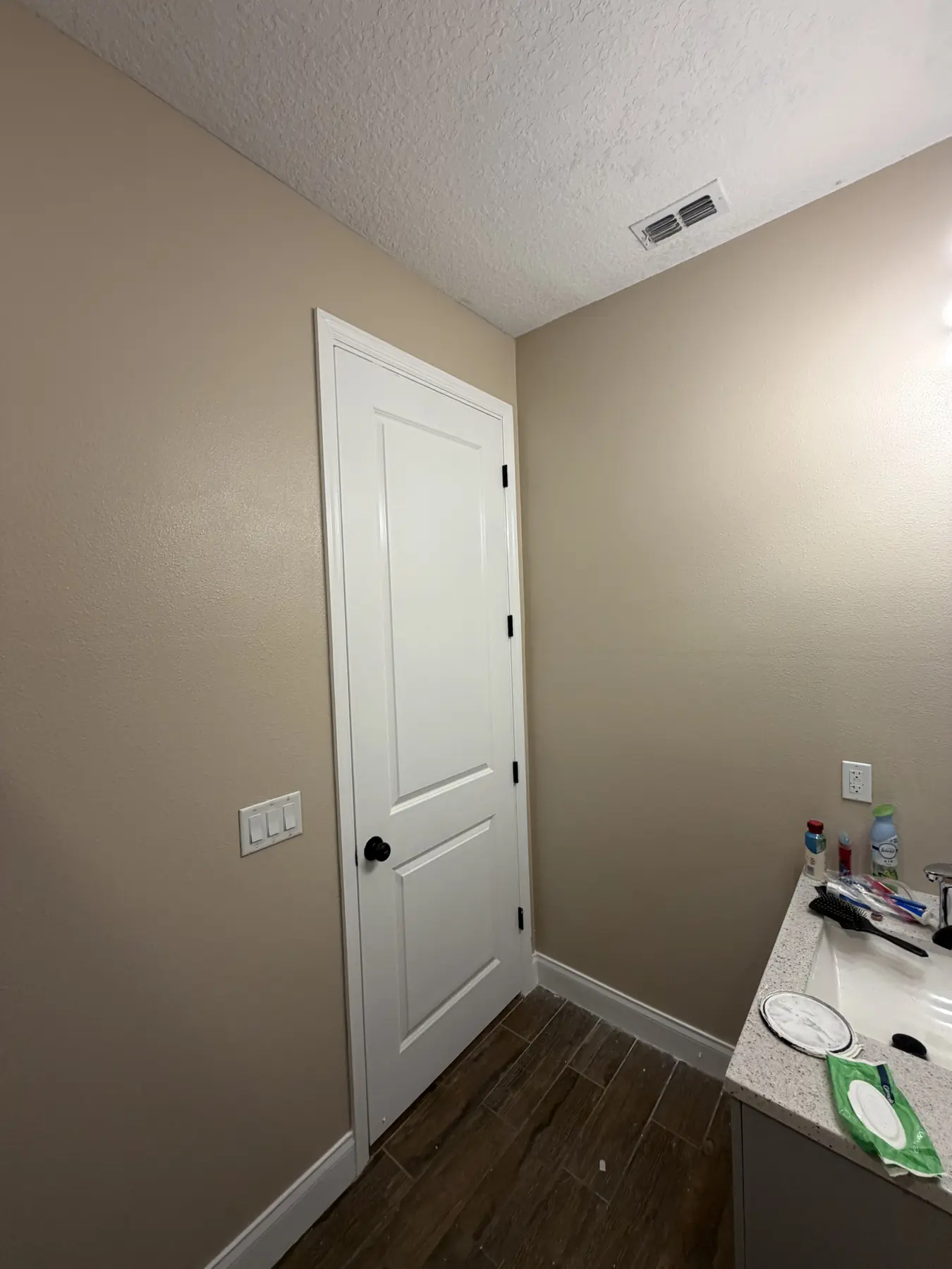 Interior door painted crisp white against warm taupe walls with painted casing and baseboard