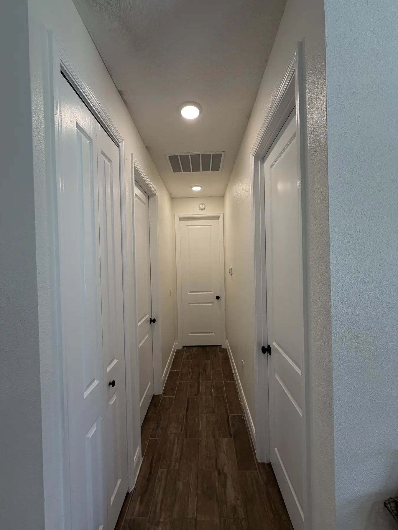 Interior hallway with freshly painted walls and ceiling and crisp white trim and doors