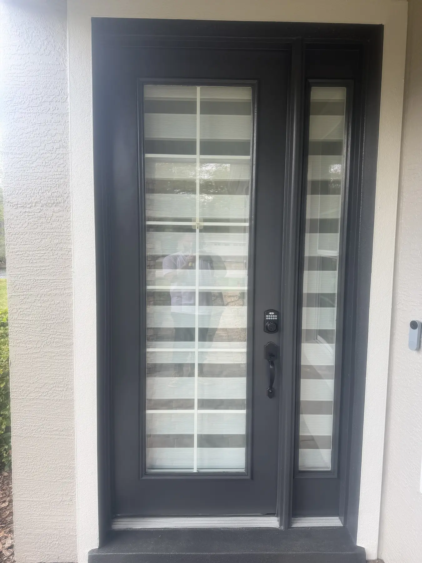 Exterior security light mounted beside a screened patio door