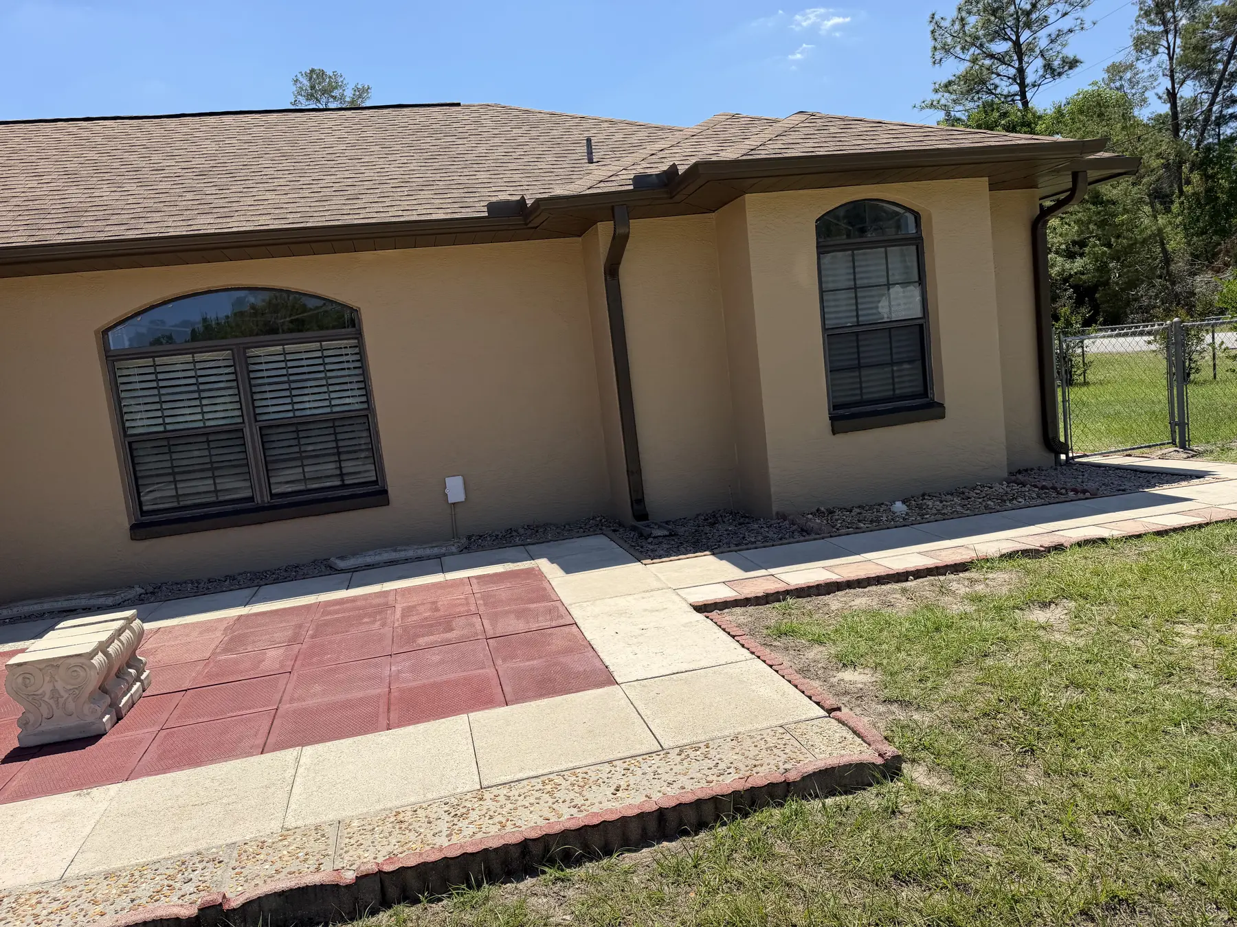 Freshly cleaned rear stucco exterior with windows and patio
