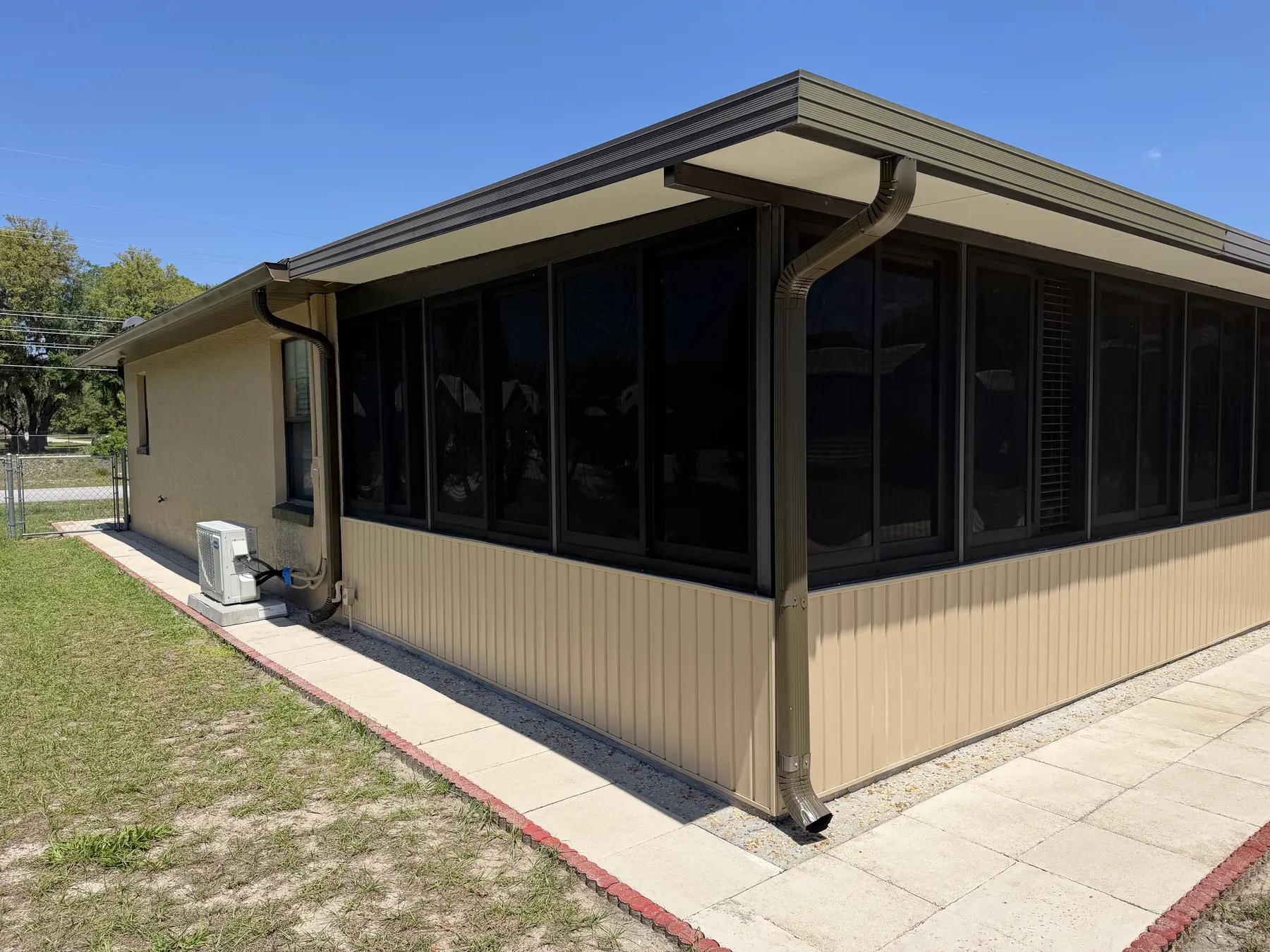 Clean screened patio enclosure along the back of a Florida home