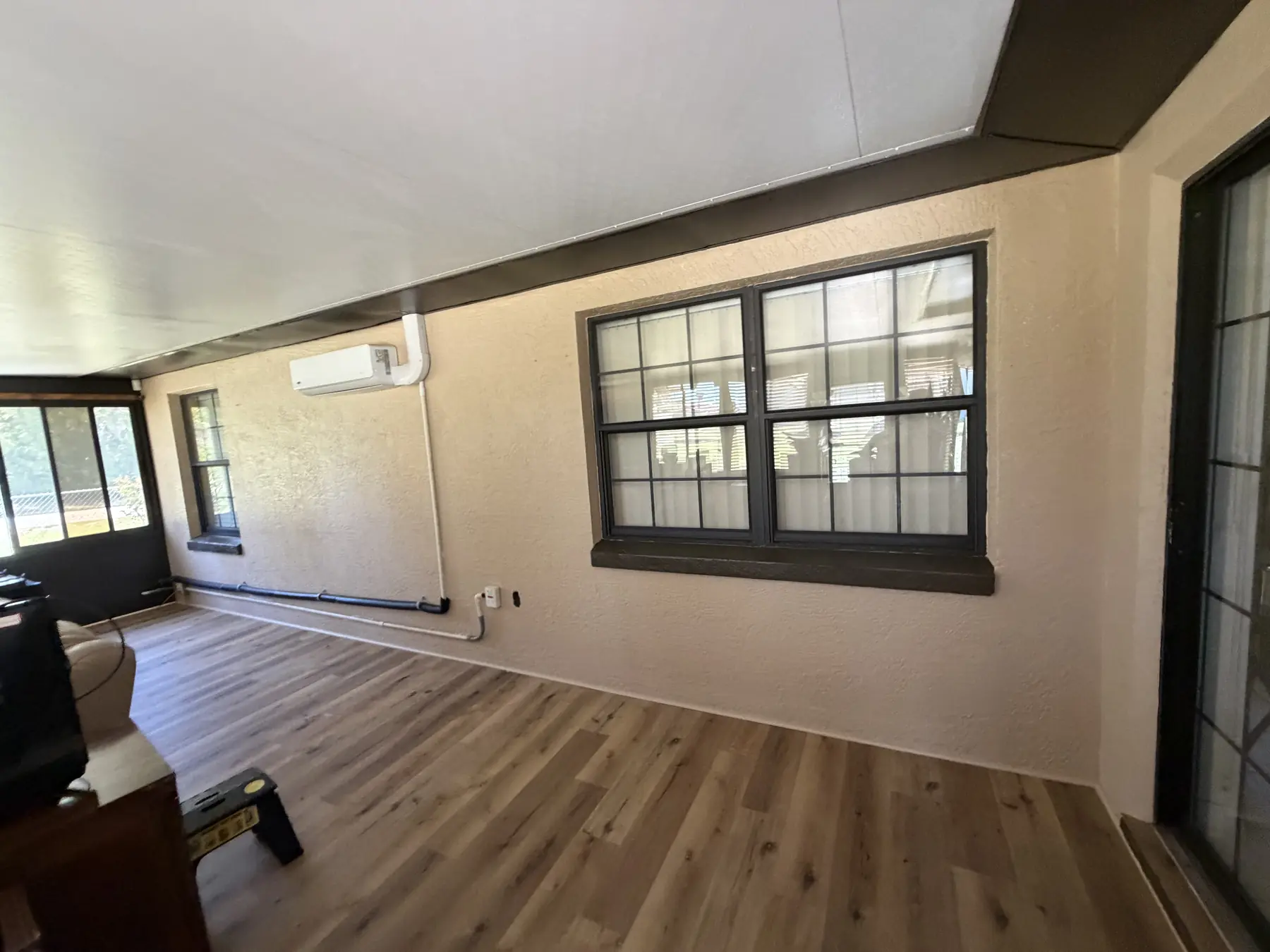 Sunroom with cream painted walls and dark brown painted window trim and sills